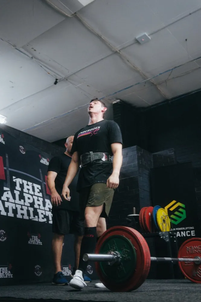 A lifter locking out a deadlift at the top of the pull